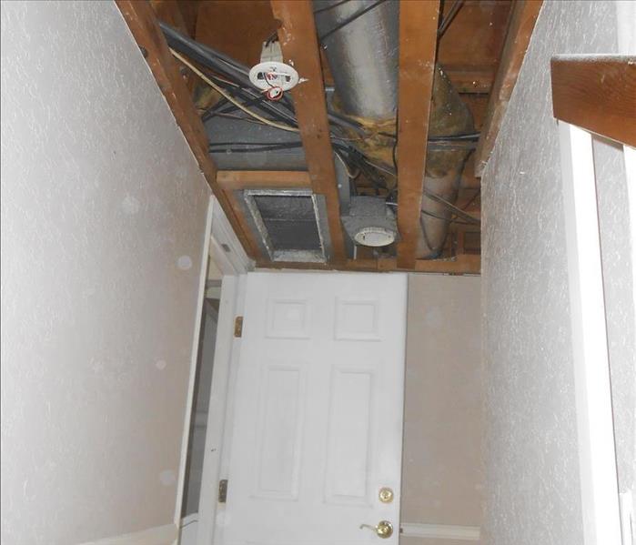 A ceiling that has been removed due to water damage. A silver air vent and ducts are visible. 