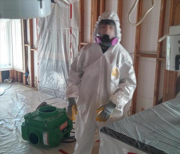 A technician pictured in a PPE suit.